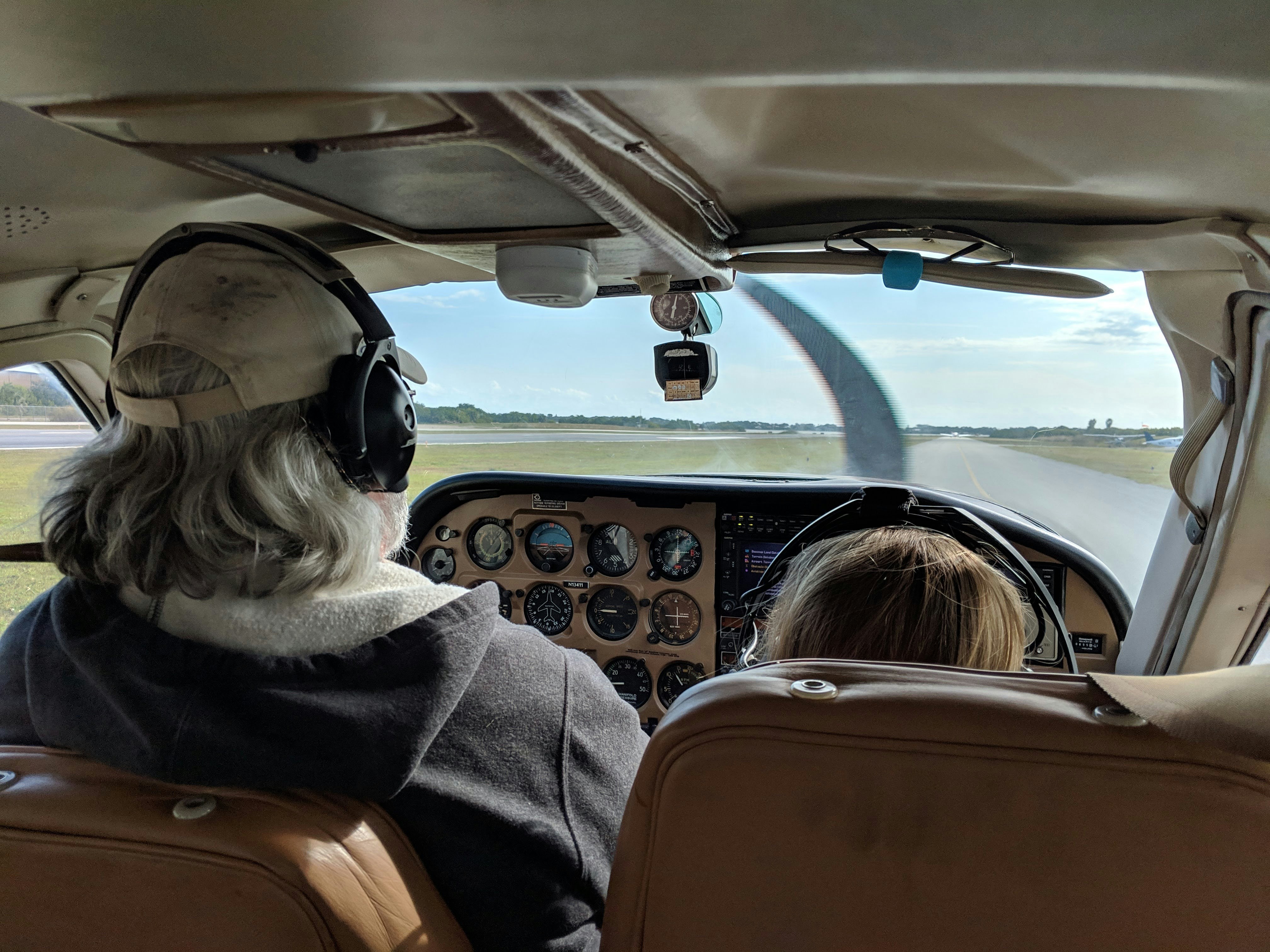 Instructor and student pilots in the cockpit of a small GA aircraft on the runway