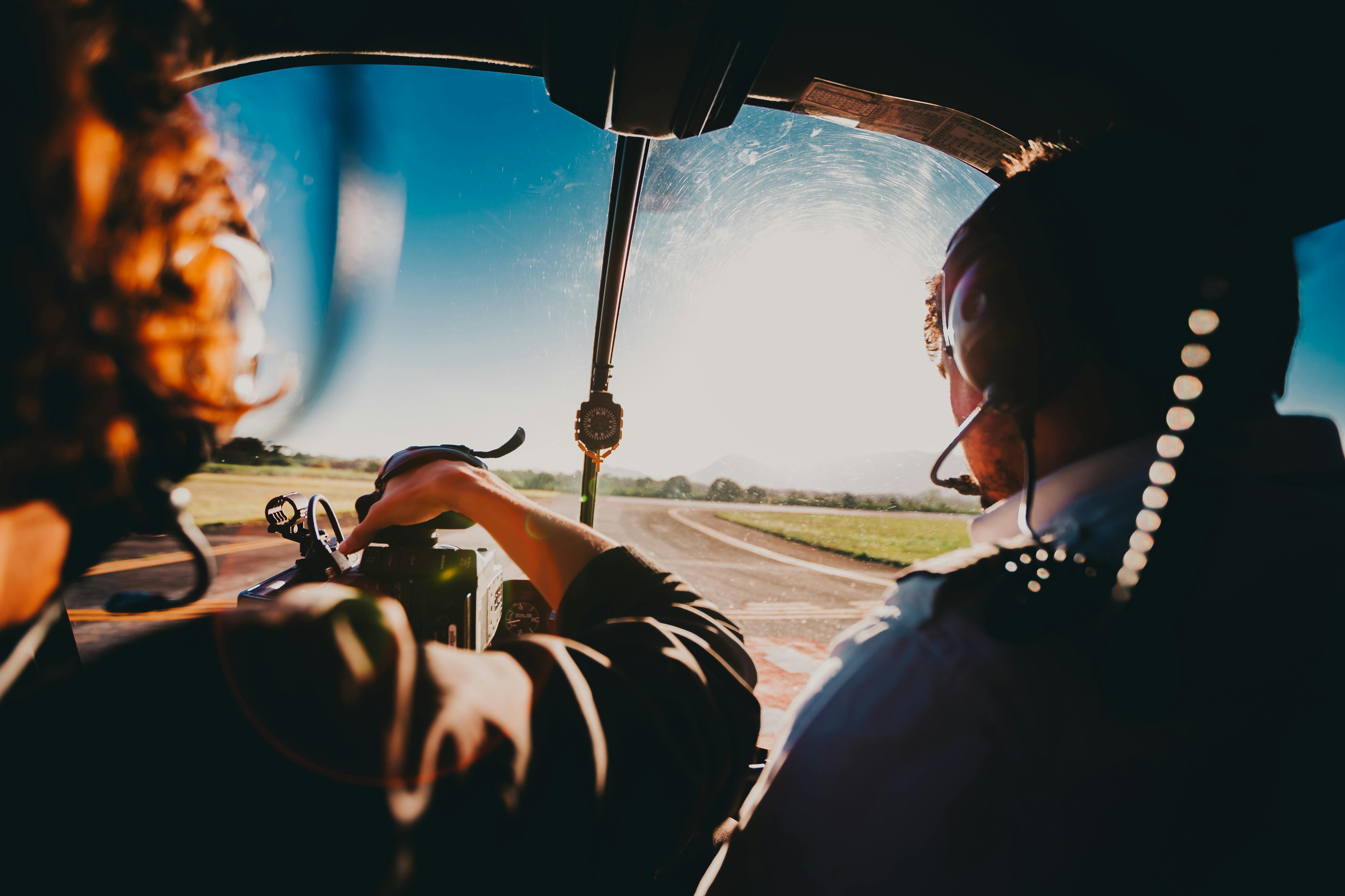 A helicopter cockpit at sunset on final approach to a runway